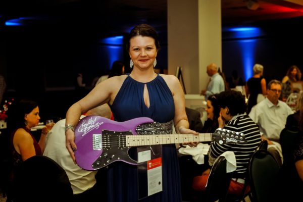 Jillian Johnson holding a Prince autographed guitar